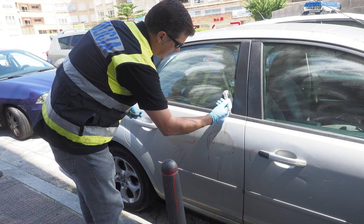 Un agente judicial examina, en agosto de 2018, el lugar donde fue asesinado un hombre tras una discusión a la salida de un pub de Santander.