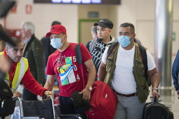 Pasajeros del vuelo procedente de Milán, unos con mascarilla, y otros, sin ella, a su llegada, ayer, al aeropuerto de Santander. 