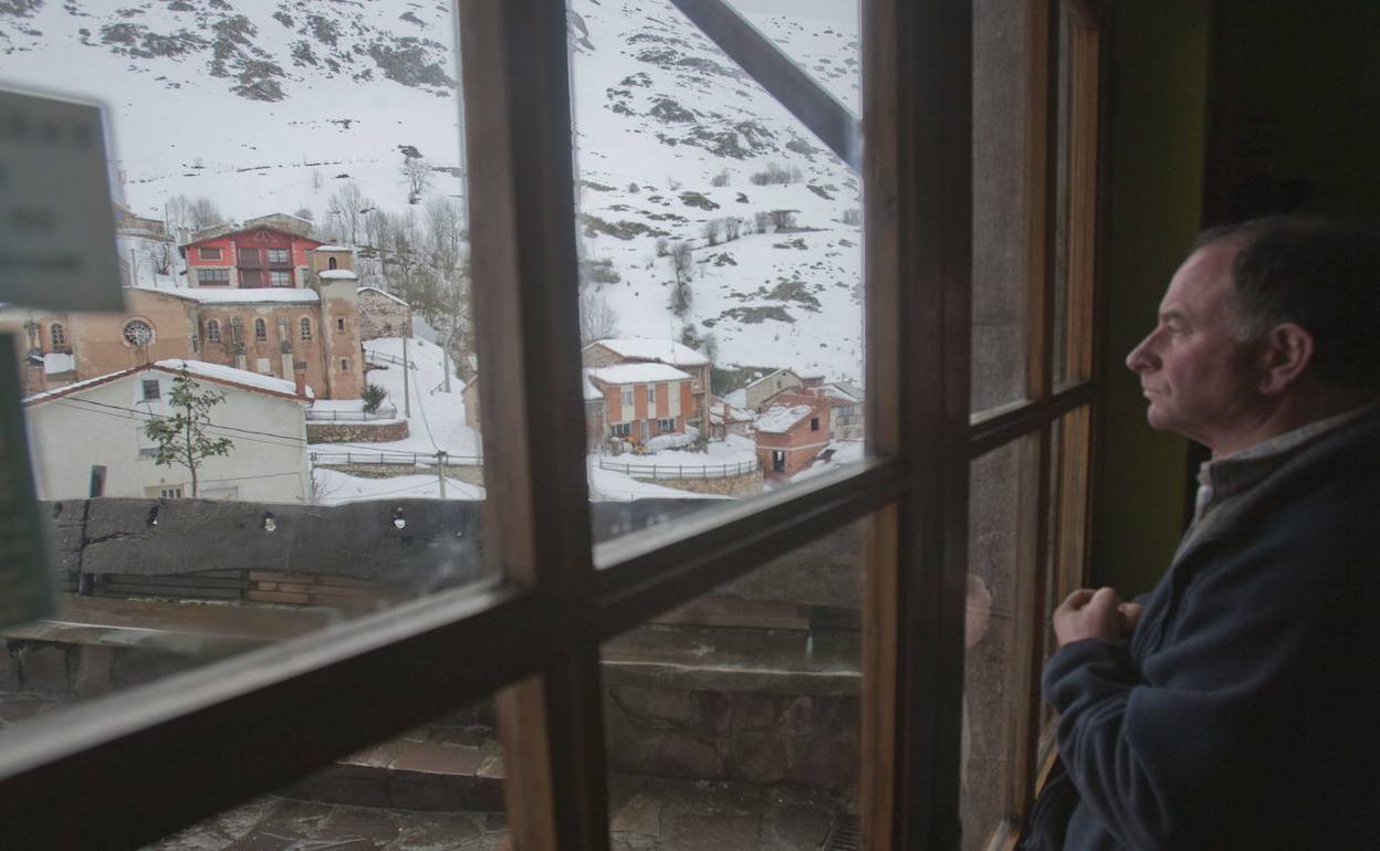 Imagen de archivo de un vecino de Tresviso mirando el paisaje nevado desde su ventana.
