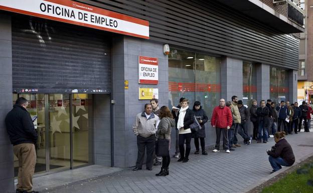 Parados haciendo cola en una oficina de empleo. 