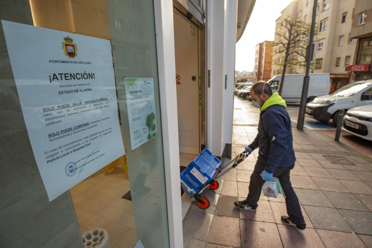 Un cliente entra a un establecimiento en el que se ha colocado a la entrada el bando municipal. daniel pedriza