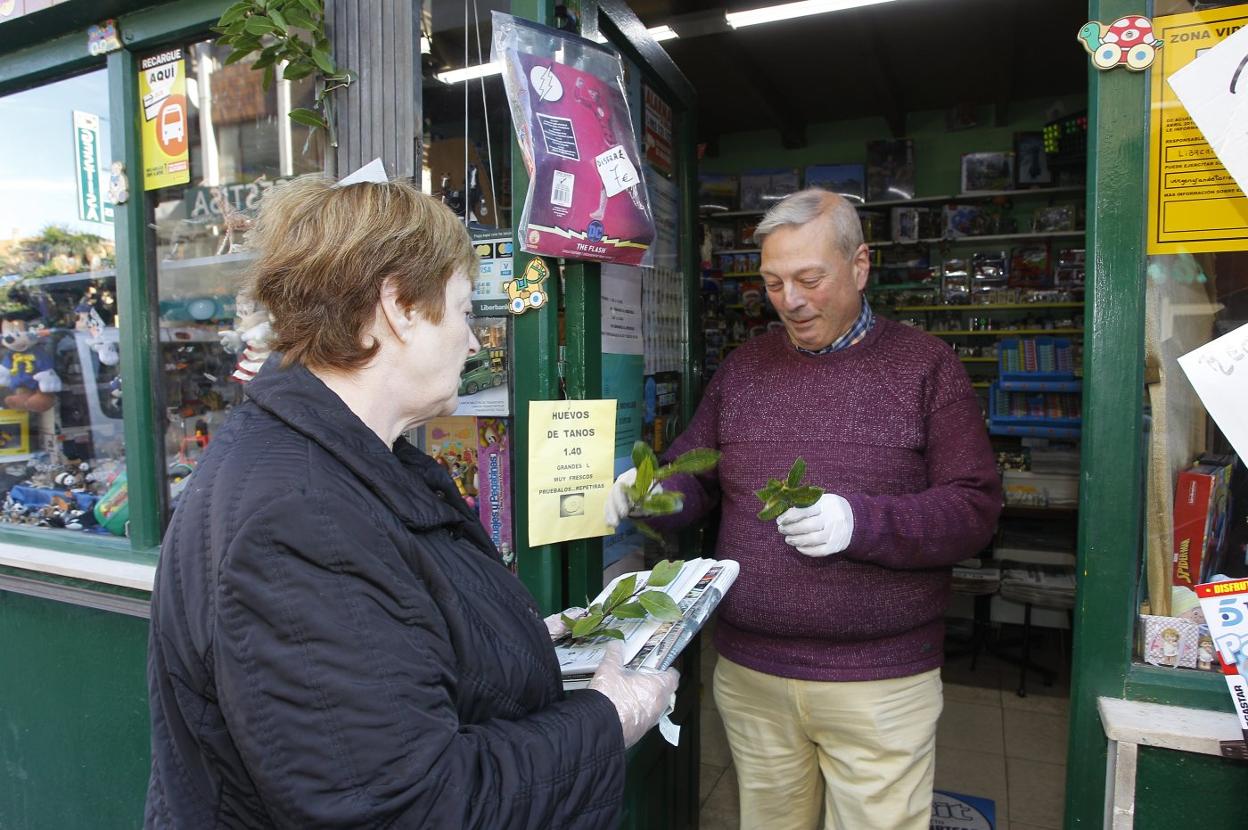Julián, quiosquero de Torrelavega, entrega un ramo de laurel a una clienta. Luis palomeque