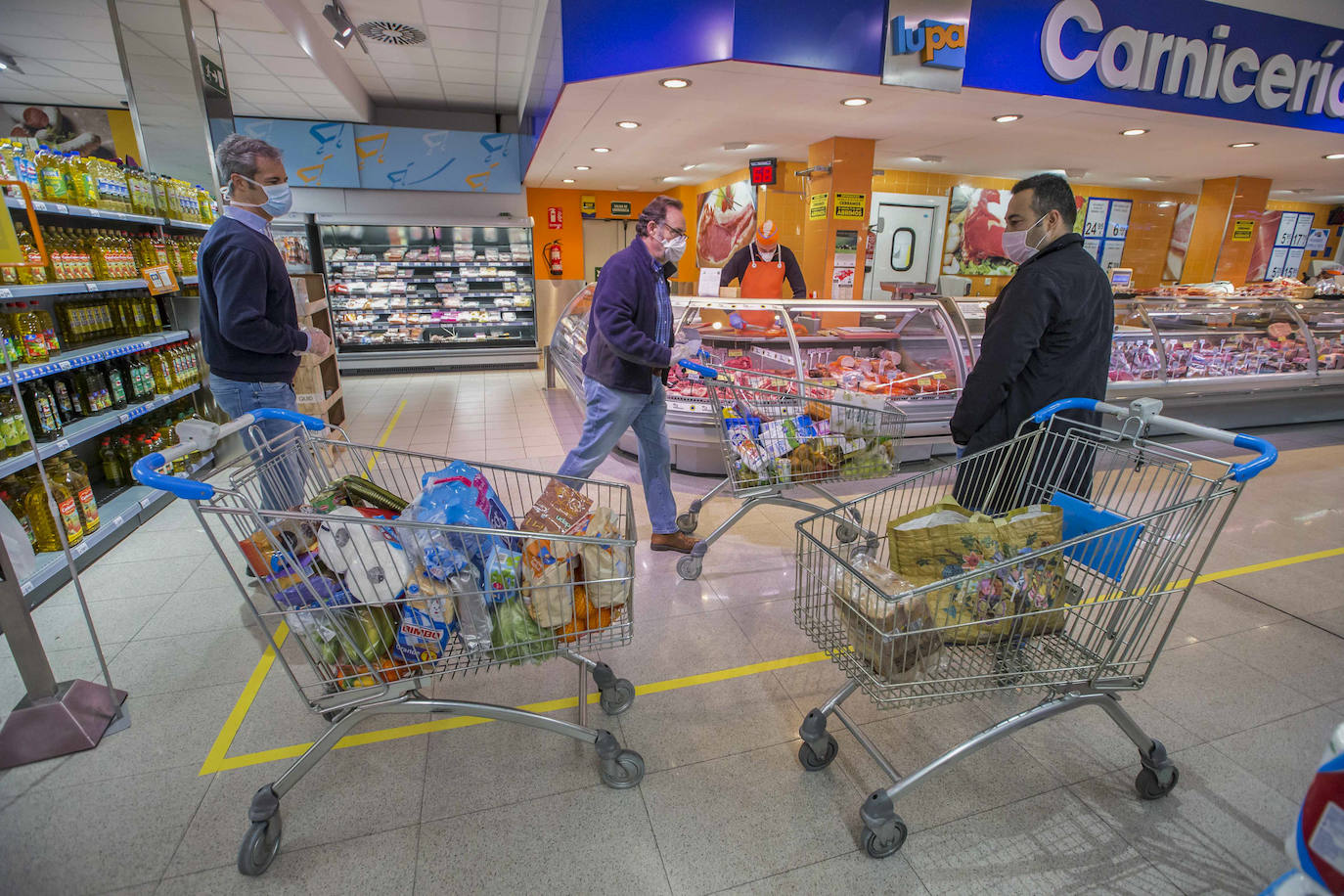 Desde primera hora de la mañana se están registrando largas colas a las puertas de supermercados y pequeñas tiendas de alimentación, para llenar la despensa antes de los días festivos de Semana Santa. En las imágenes, establecimientos de Torrelavega, El Astillero y el centro de Santander y el barrio Valdenoja.