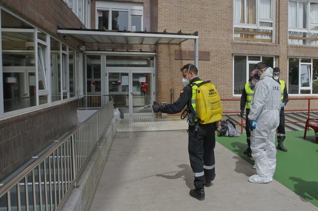 Soldados de la Unidad Militar de Emergencia (UME) desinfectan el exterior de la Fundación Asilo de Torrelavega, donde se han detectado 30 positivos por coronavirus.