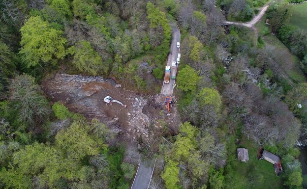 Excavadoras y camiones retiran las cientos de toneladas de tierras que han cortado la carretera. 