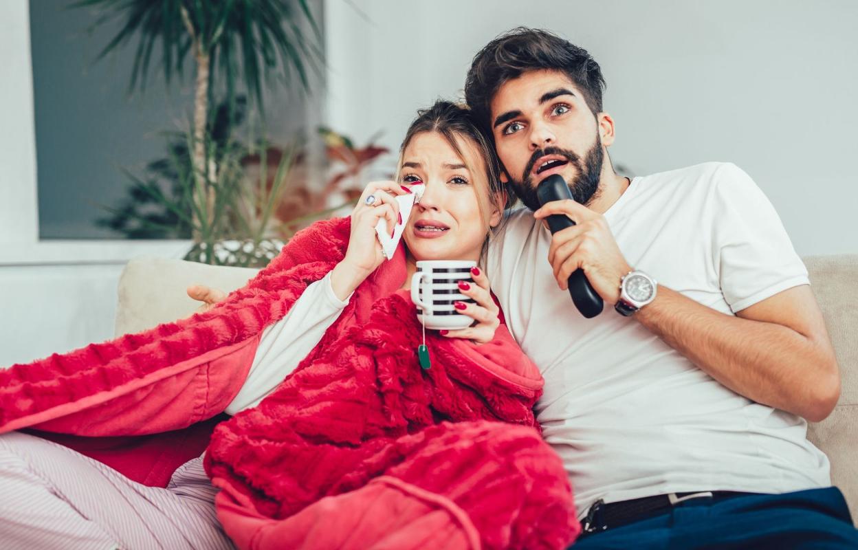 Una pareja disfruta de una sesión de cine en casa.