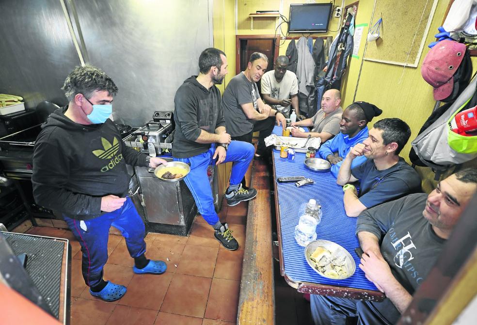 La tripulación del pesquero 'Bustillo Donosti', en la cocina, conversando, mientras llega la comida tras la dura jornada de trabajo.