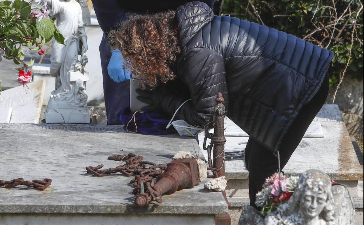 Una mujer ante la lápida de un familiar fallecido, en el cementerio de Ciriego.