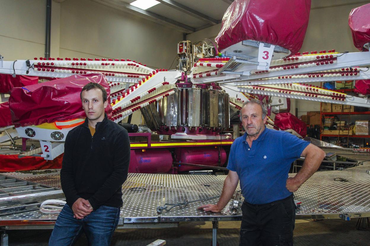 Diego Nieto y su padre, José Manuel, junto al 'Saltamontes', una de las atracciones parada que tienen en una nave. 