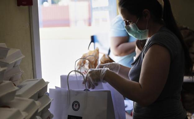 Unas mujeres preparan bolsas. 