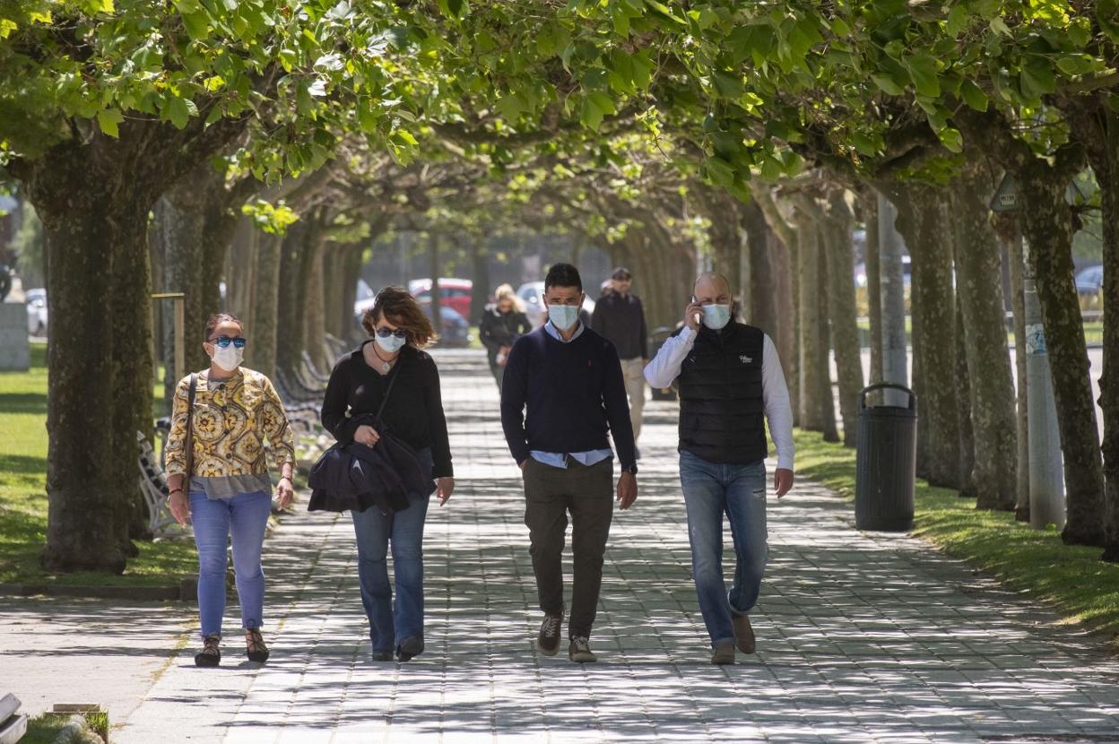 Un grupo de personas con mascarilla pasea por una calle de Santander. 