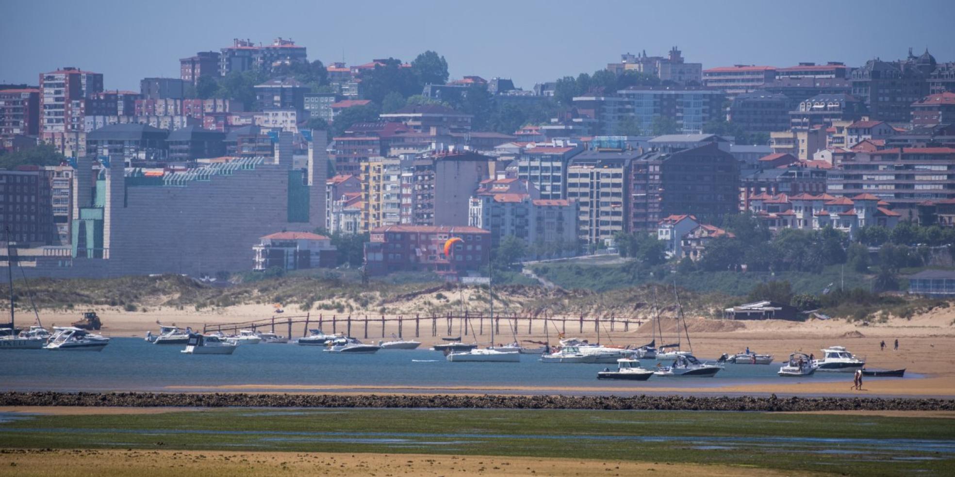 Veleros y motoras llenan las aguas del interior de la bahía junto a la playa de El Puntal. 