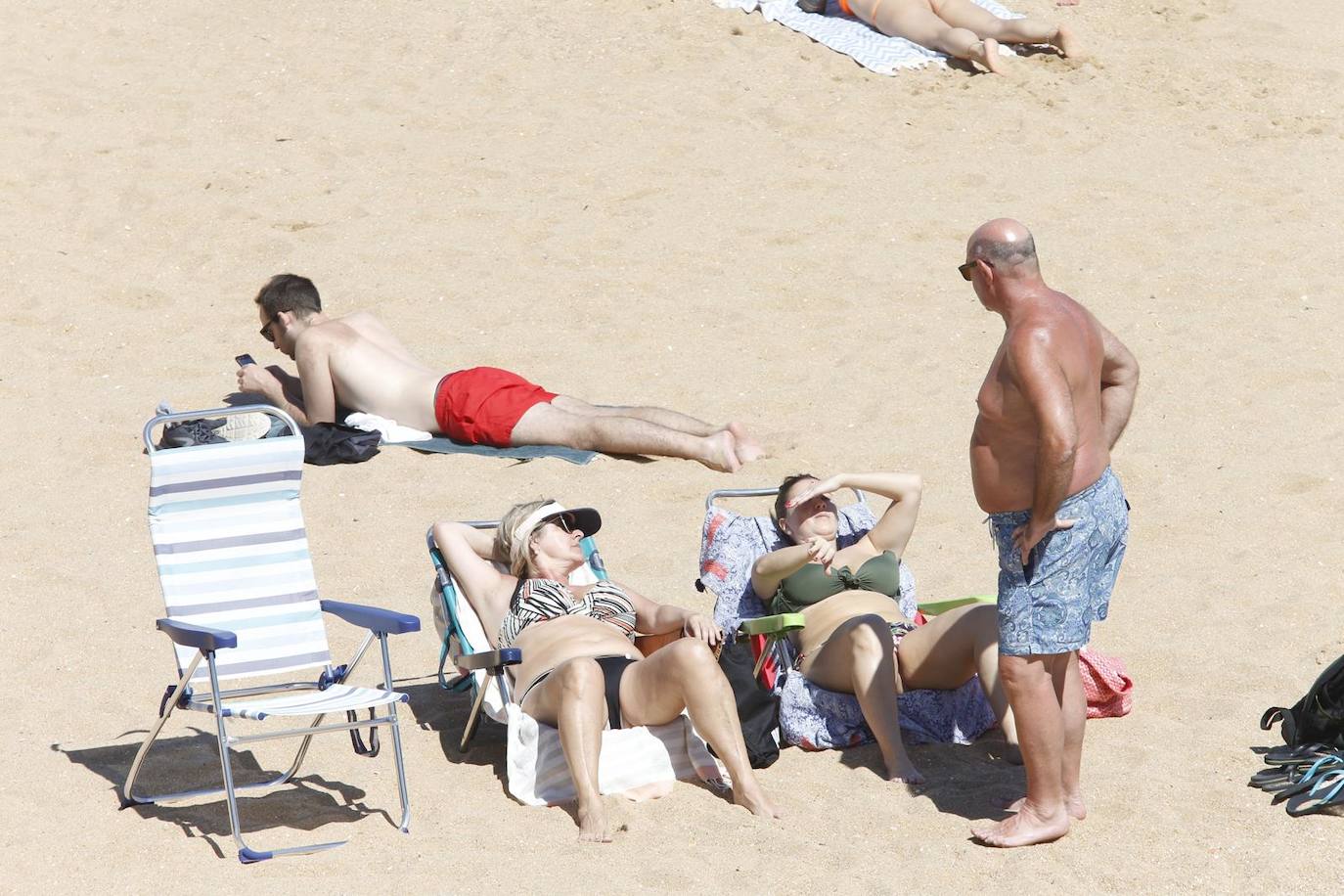 Aspecto que presentan este sábado las playas de El Sardinero y de la bahía de Santander, con muchos bañistas, gente paseando por la orilla, disfrutando del mar y tomando el sol.