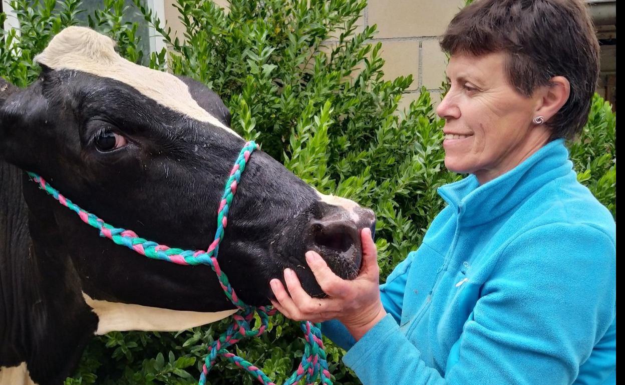 Charo, junto a una vaca frisona de su ganadería. 