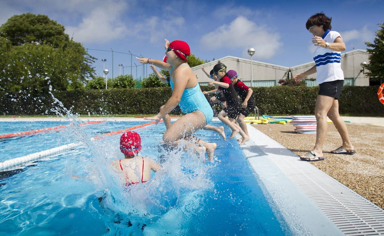 Niños iniciándose en la natación en la piscina del Complejo de La Albericia durante 'El Veranuco'.