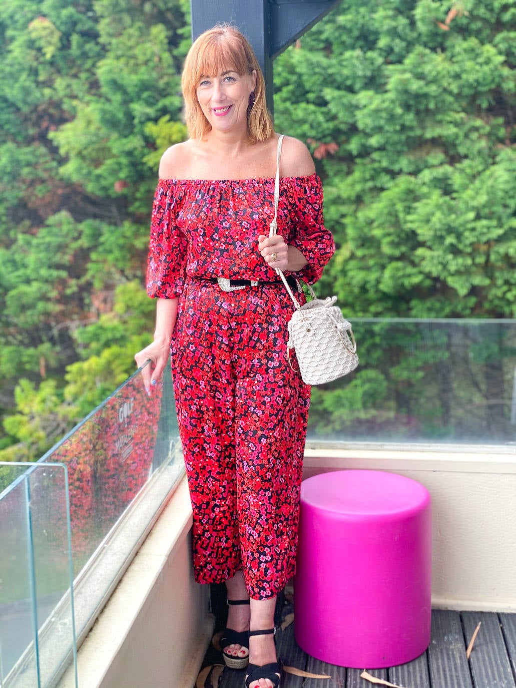 Gema estaba de estreno, un bonito conjunto regalo de cumpleaños formado por top con escote bardot, para ella uno de los que más me favorecen, y pantalón culotte. El estampado de flores de colores en rojos, negros y rosas es muy veraniego y alegre. Lo combinó con cuñas de esparto negras y un bolso de crochet de estilo rústico.