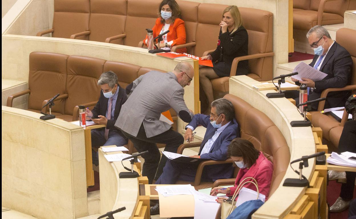 Félix Álvarez y Revilla se saludan con el codo en el Pleno del Parlamento de este lunes.