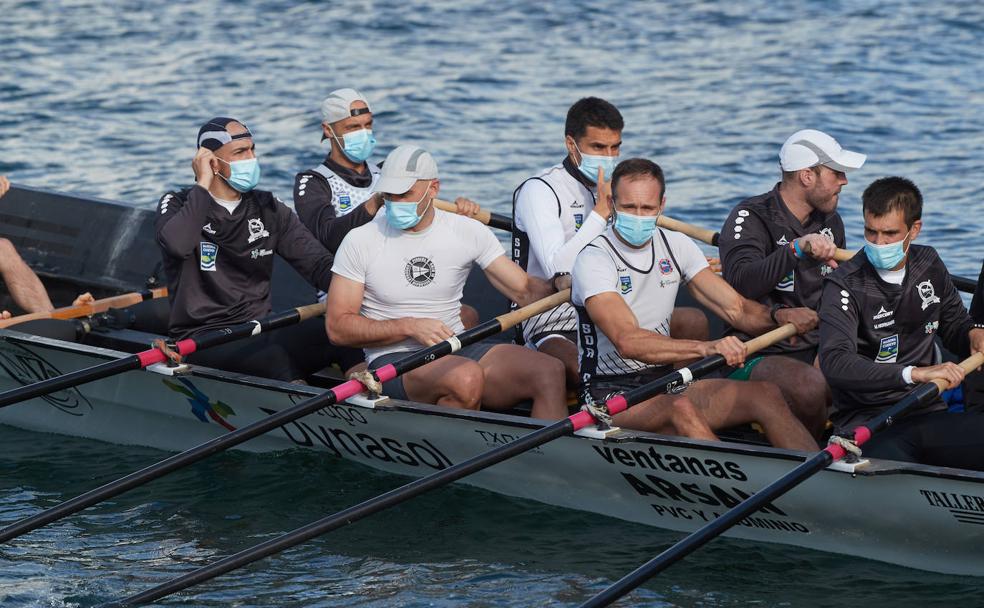 Una de las embarcaciones que Pedreña ha echado este martes al agua, con los remeros ataviados con mascarillas.