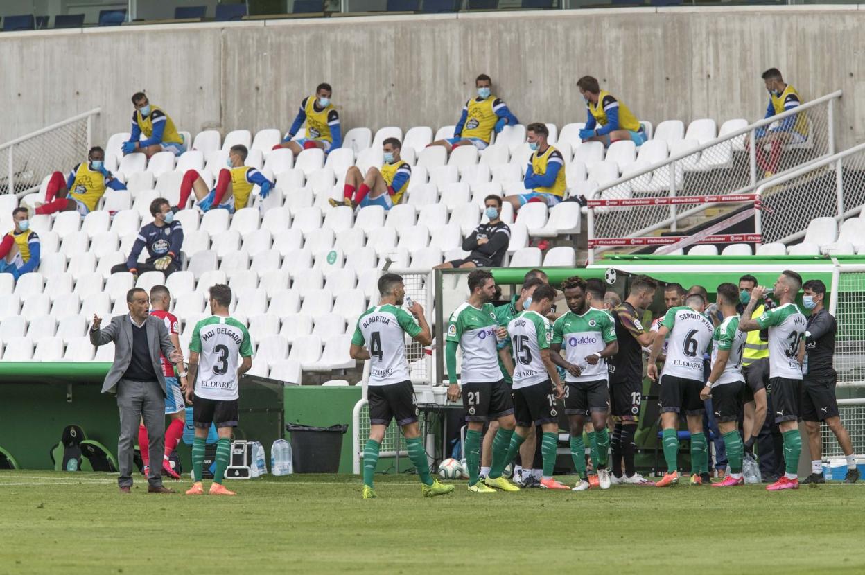 Los jugadores del Racing se refrescan en uno de los parones para hidratarse durante el partido ante el Lugo.