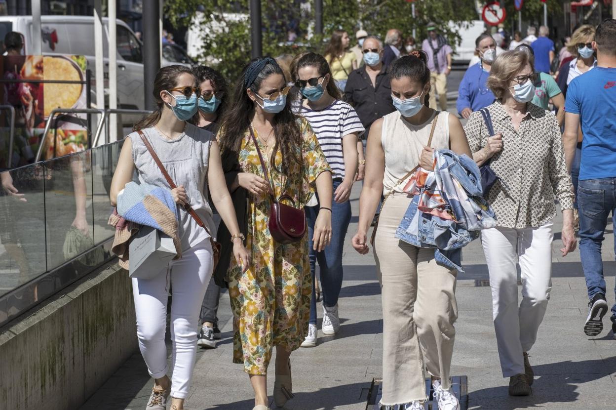 El número de habitantes, junto a la incidencia de la pandemia en cada territorio, ha sido el factor que más peso ha tenido a la hora de decidir el reparto del fondo extraordinario no reembolsable de Hacienda, En la imagen, ciudadanos protegidos con mascarillas pasean por las calles de Santander