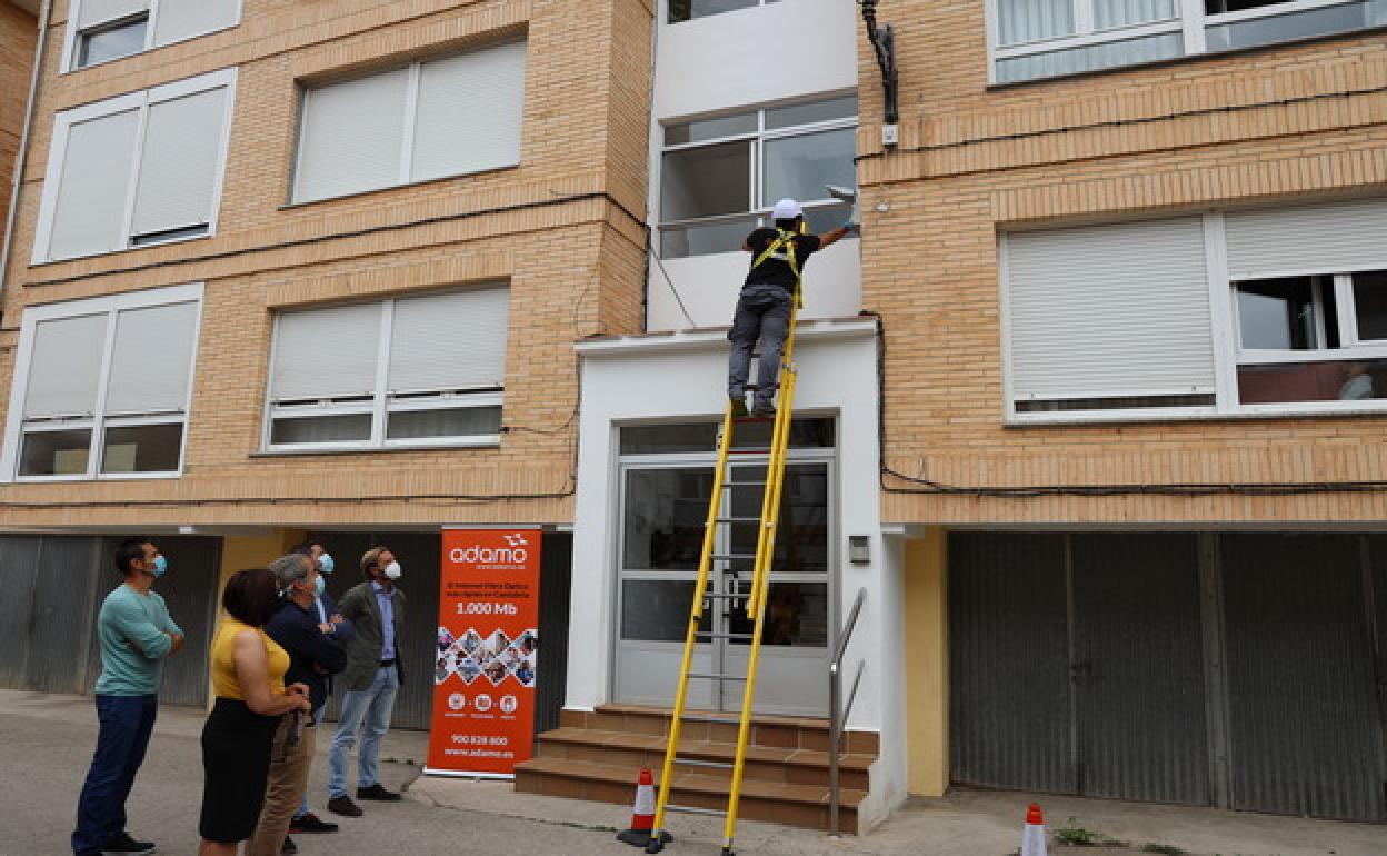 Momento en que un técnico de la empresa Adamo da la conexión de fibra óptica al primer abonado en la villa de Potes, en presencia de autoridades y técnicos