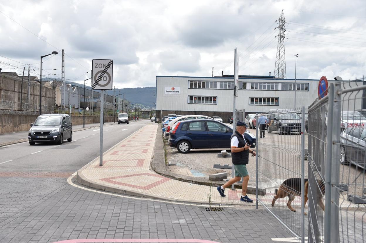 Un vecino pasea a su perro frente al aparcamiento de La Vidriera, la semana pasada, en Maliaño (Camargo).