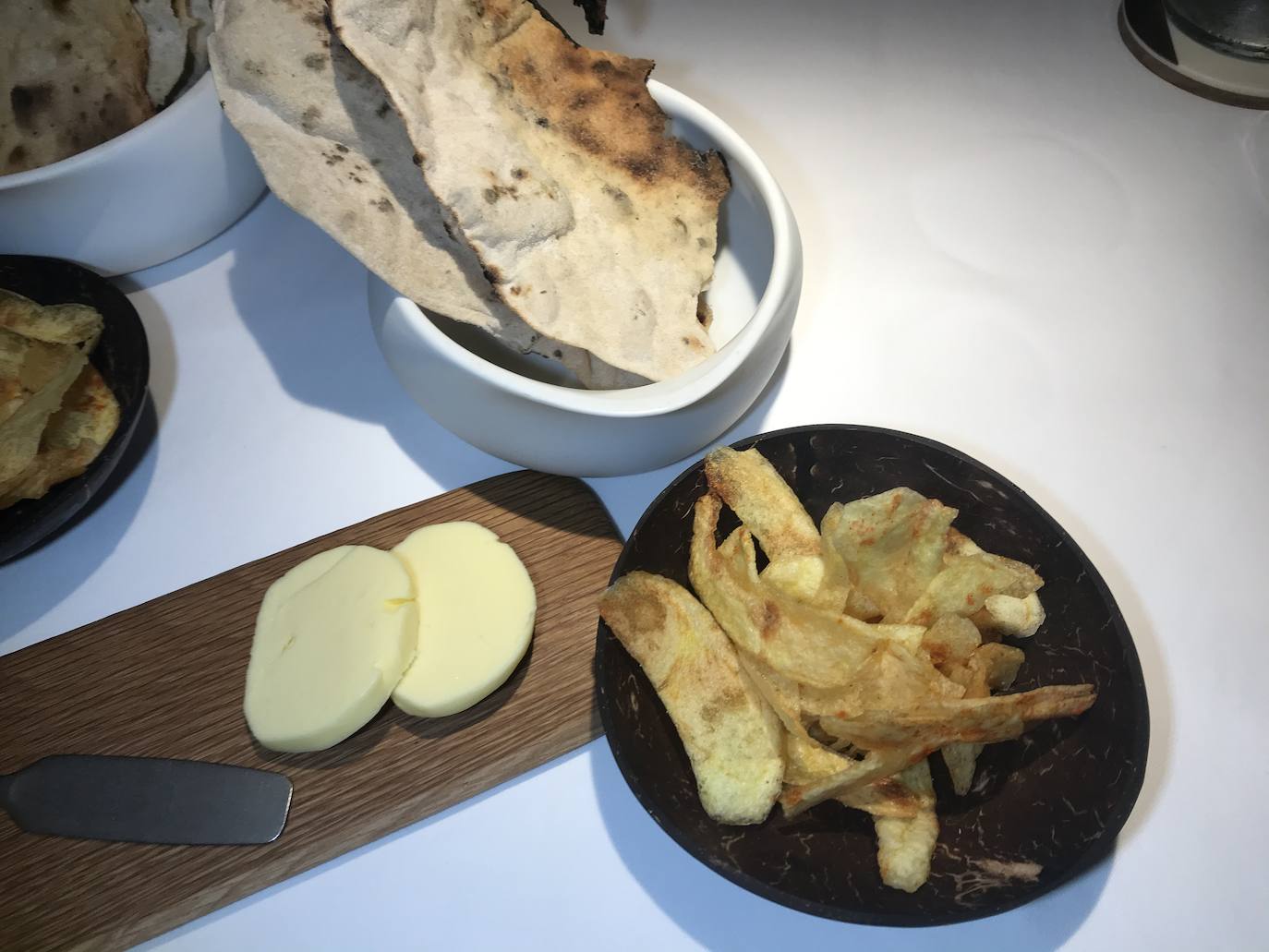 Patatas fritas –chips– aderezadas con pimentón, con una mantequilla pasiega de La Jarradilla y con un pan horneado de La Pizzicleta. 