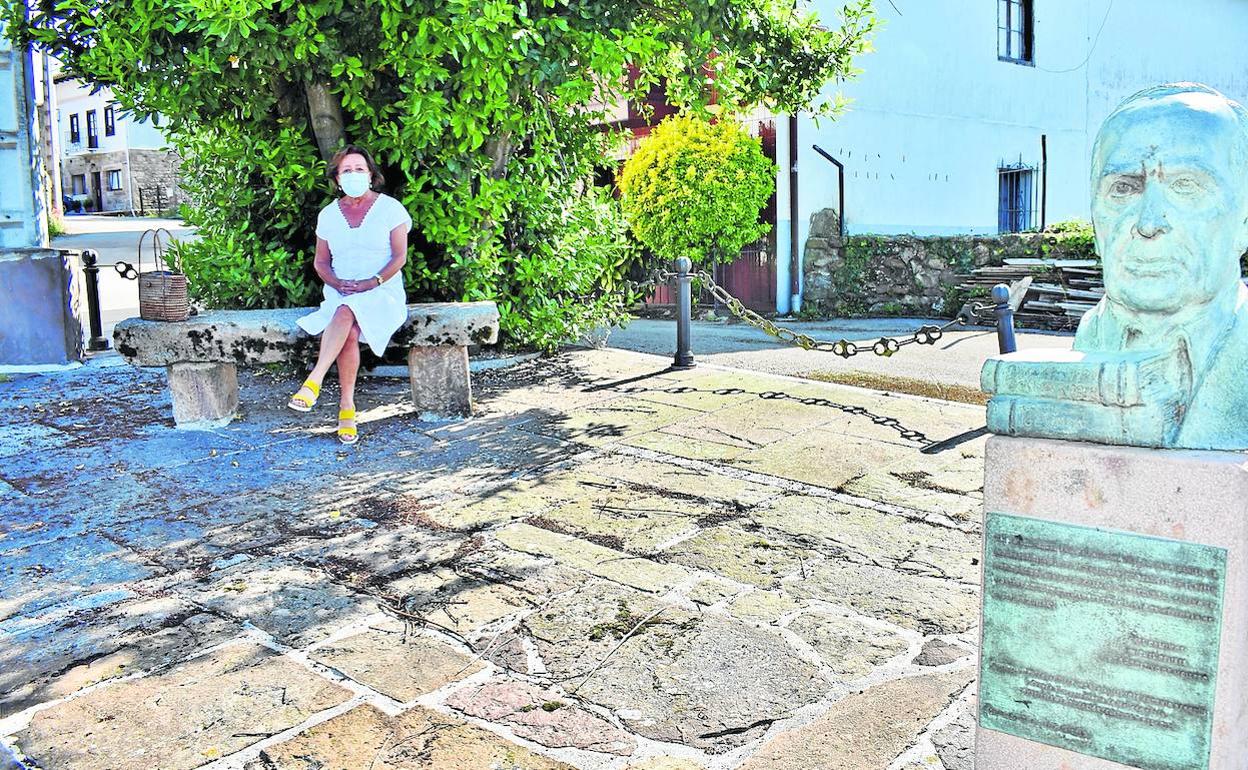 Carmen Múgica, sentada en la plaza sobre la que se levanta el busto dedicado al escritor Miguel Delibes en Molledo