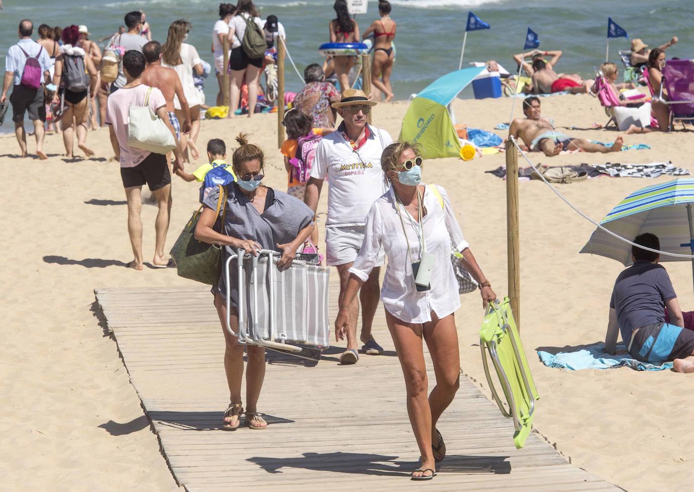 Cientos de bañistas han disfrutado este sábado de las playas de El Sardinero, en una jornada plenamente veraniega marcada por el uso obligatorio de la mascarilla y la restricción de los aforos. En algunos momentos, algunos de los arenales colgaron el cartel de 'completo'.