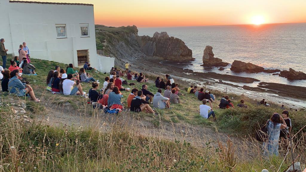 Numerosas personas, muchas de ellas con mascarillas y guardando las distancias, se congregaron ayer en los acantilados de la playa de La Arnía (Piélagos) para contemplar la puesta de sol. Un maravilloso espectáculo que regala la naturaleza en Cantabria.