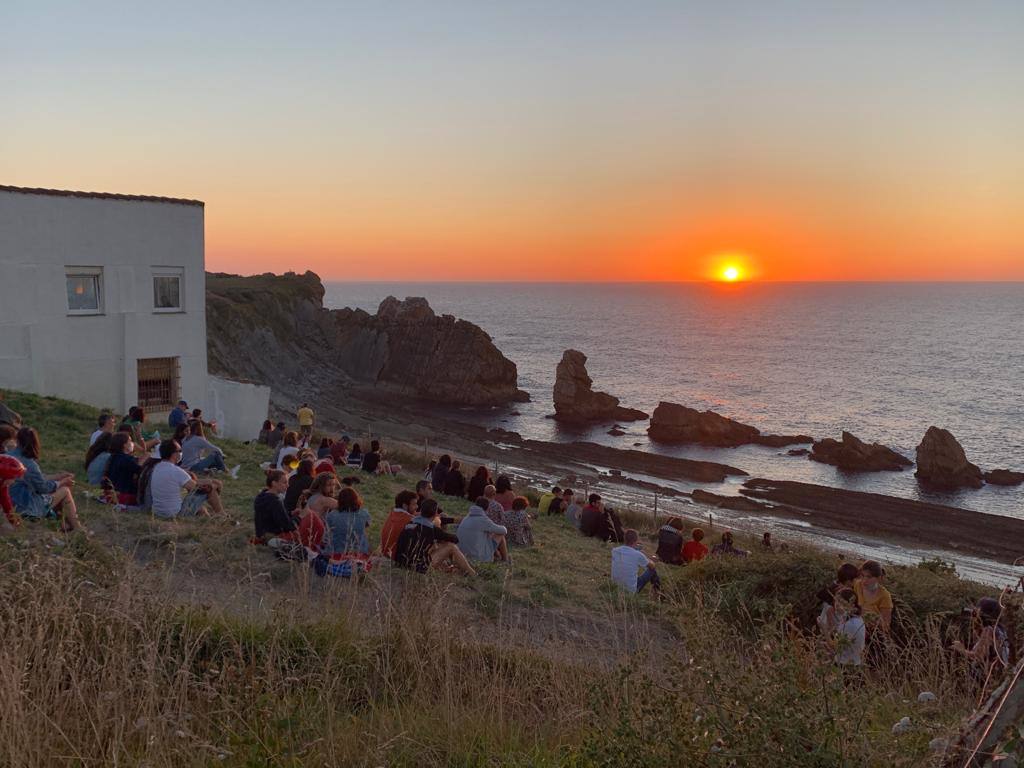 Numerosas personas, muchas de ellas con mascarillas y guardando las distancias, se congregaron ayer en los acantilados de la playa de La Arnía (Piélagos) para contemplar la puesta de sol. Un maravilloso espectáculo que regala la naturaleza en Cantabria.