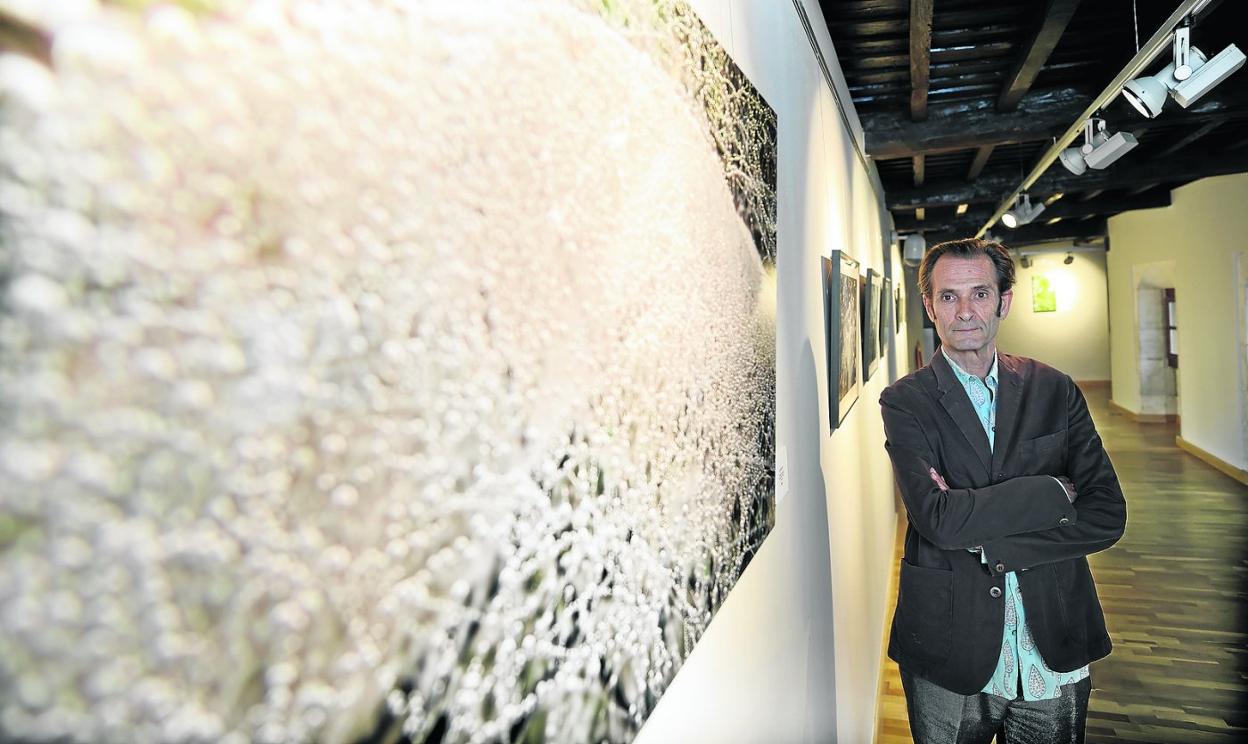 El fotógrafo Pablo Crespi posa junta a una de sus obras en el centro cultural El Espolón, de Comillas. 