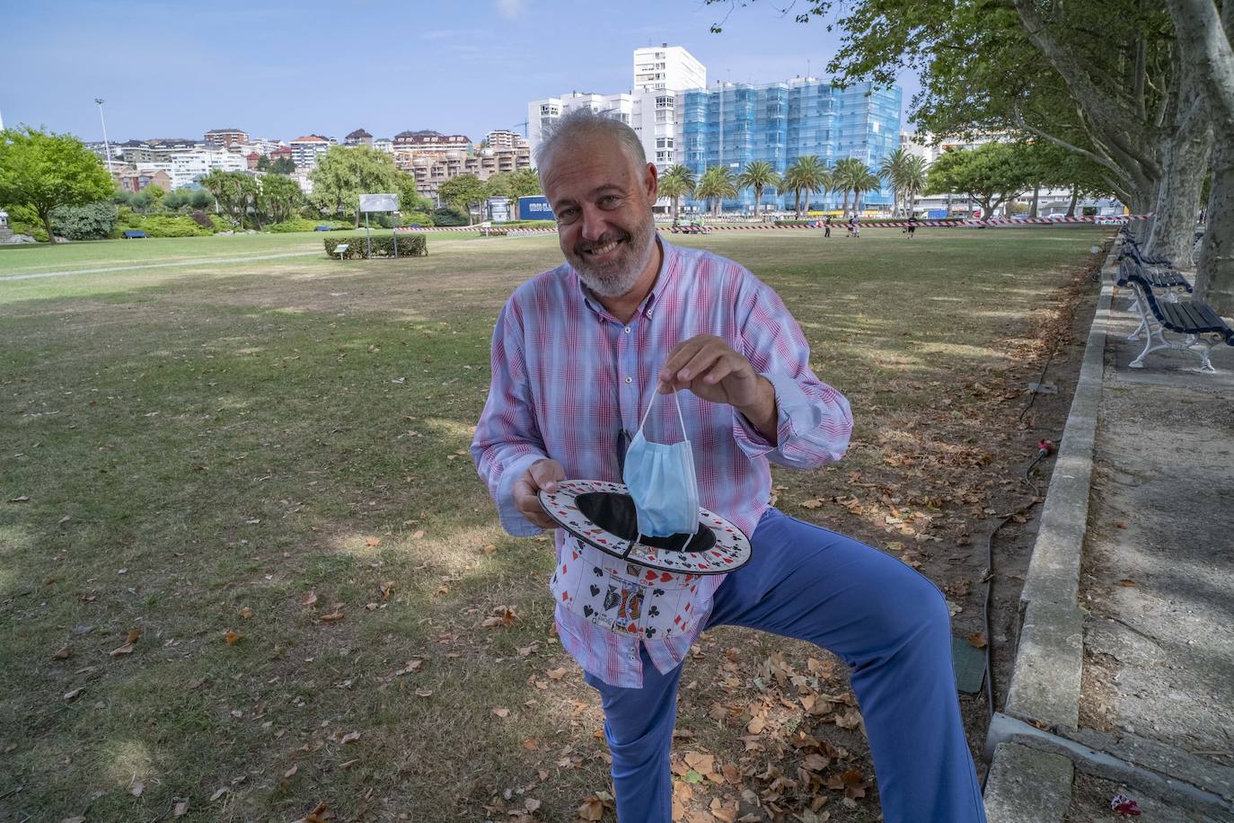 El mago César Bueno con su chistera de la saca una mascarilla, en el parque de Mesones, este año sin casetas ni actividades de calle.