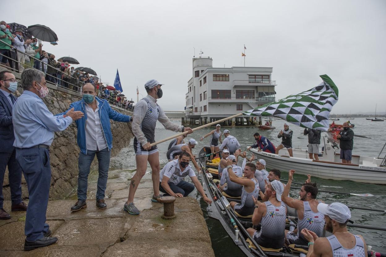 Los remeros de Pedreña celebran su triunfo mientras ondean la bandera.