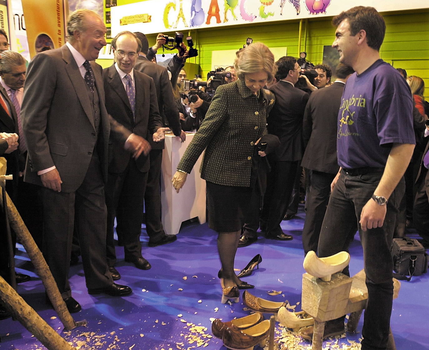 Imagen de 2003 de la visita de los Reyes de España al pabellón de Cantabria, en Fitur. La reina Sofía probándose unas albarcas.