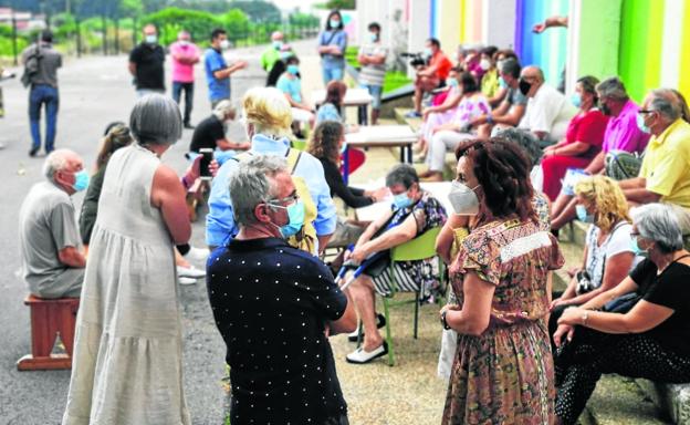 Varios vecinos conversan en grupos en las mesas de Cueto y Monte antes de poner ideas en común. 