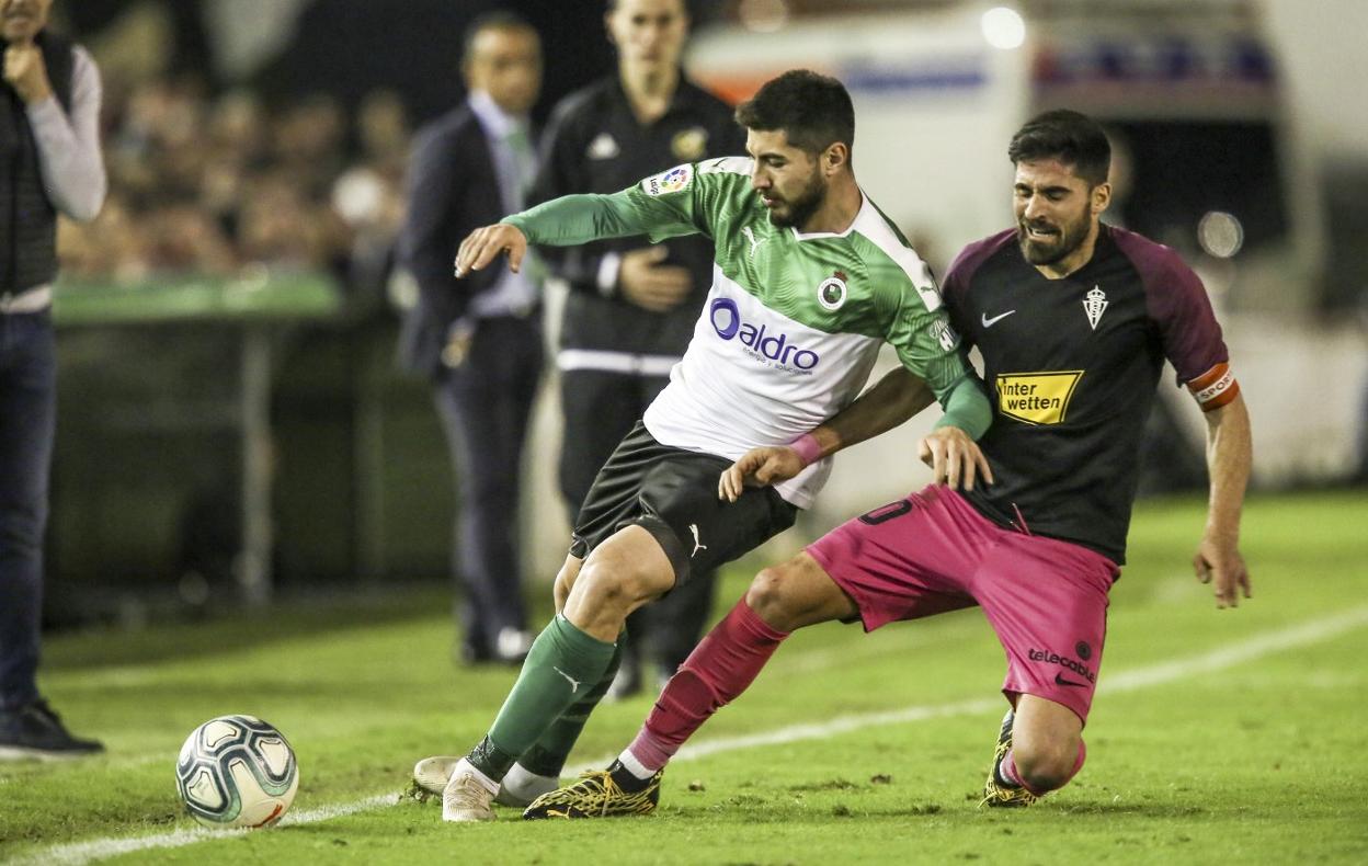 Nando pelea por el balón ante un rival del Sporting durante el partido de Liga que se disputó en los Campos de Sport de El Sardinero.