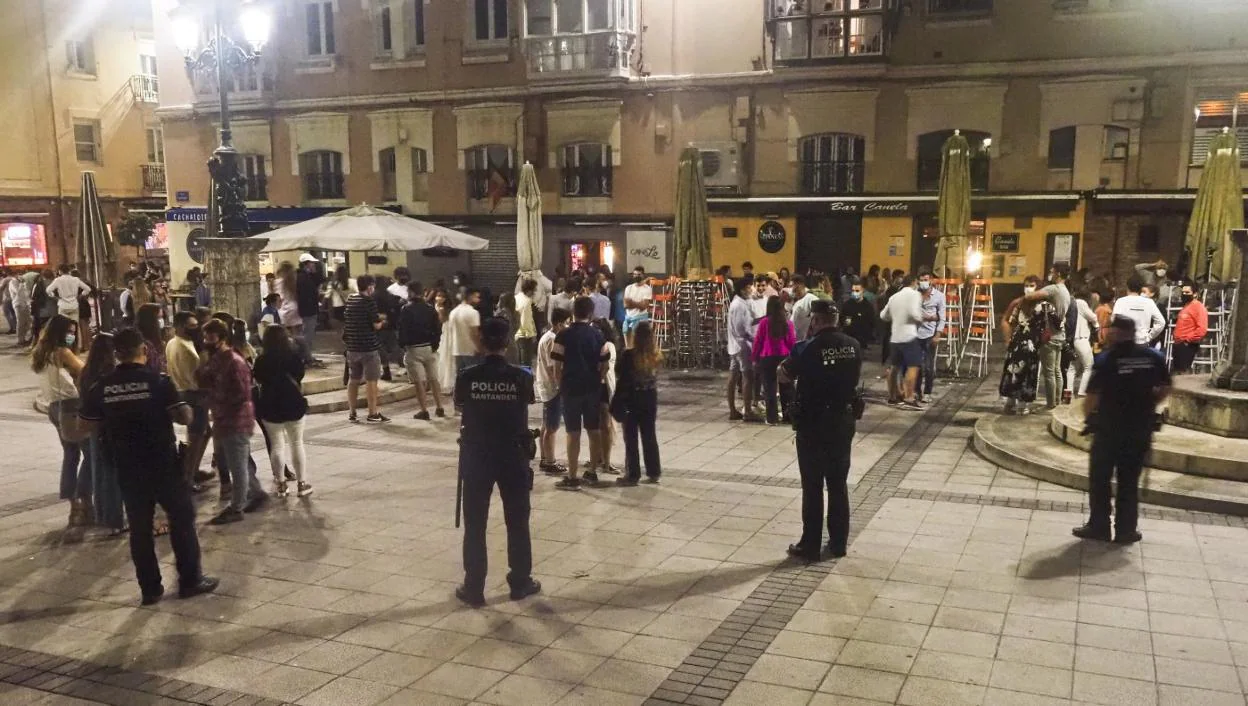 Un grupo de agentes de la Policía Local de Santander vigila el cumplimiento de las normas sanitarias durante la noche en la Plaza de Cañadío. 