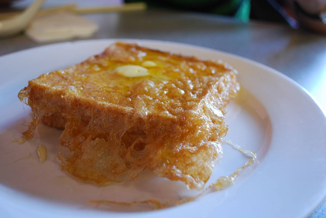 38- Tostadas francesas, Hong Kong | Rodajas de pan fritas mojadas en huevo o soja batida, y servidas con mantequilla y cubiertas con miel de caña o miel normal.