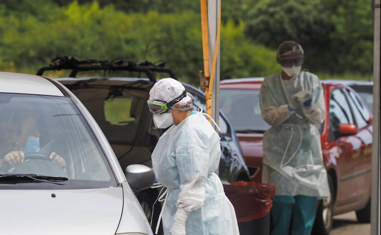 Personal sanitario toma muestras para PCR a las personas citadas en el 'coroauto' de Liencres, donde ayer se repitieron las colas