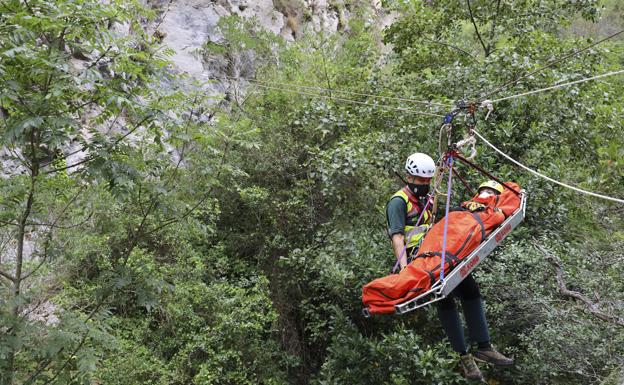 Imagen. Un agente traslada a un herido mediante un sistema de cuerdas suspendidos a gran altura. Las imágenes son de su entrenamiento esta semana. 