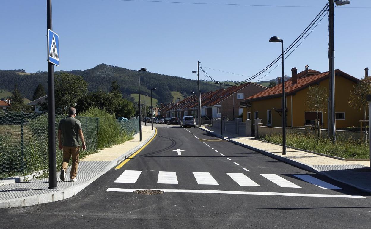 Un vecino camina por el nuevo vial construido frente al colegio público de Tanos