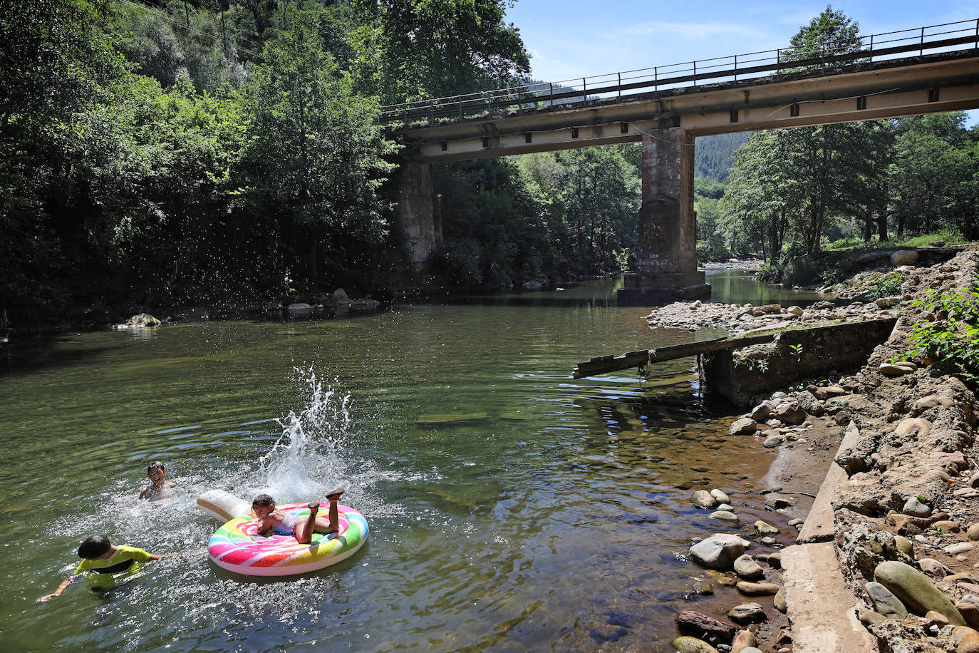 Los cauces y pozos son más que nunca un reclamo para los turistas estos días de calor, unos espacios que comparten con los vecinos. En estas imágenes, niños y mayores disfrutan en el río Saja, en el parque de Santa Lucía de Cabezón de la Sal.