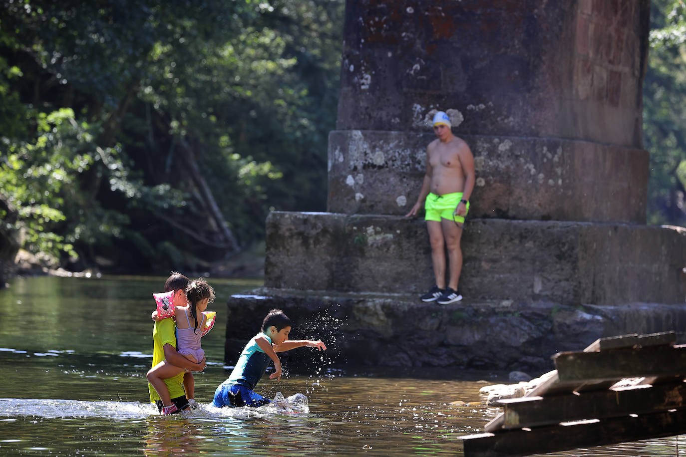 Los cauces y pozos son más que nunca un reclamo para los turistas estos días de calor, unos espacios que comparten con los vecinos. En estas imágenes, niños y mayores disfrutan en el río Saja, en el parque de Santa Lucía de Cabezón de la Sal.