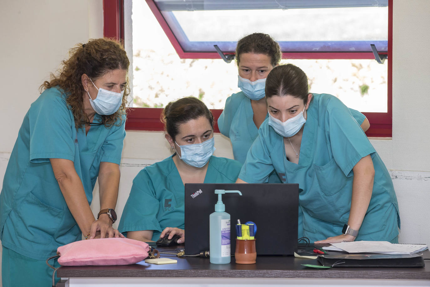 Cuatro profesionales examinan unos datos en el ordenador.