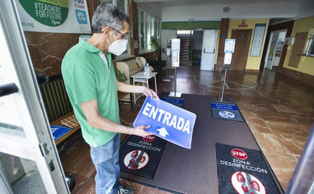 Acceso escaonado. José Antonio Sánchez Raba, director del Colegio Cisneros de Santander, muestra la señalítica para los accesos por turnos y distintos horarios, con felpudos de desinfección y gel.