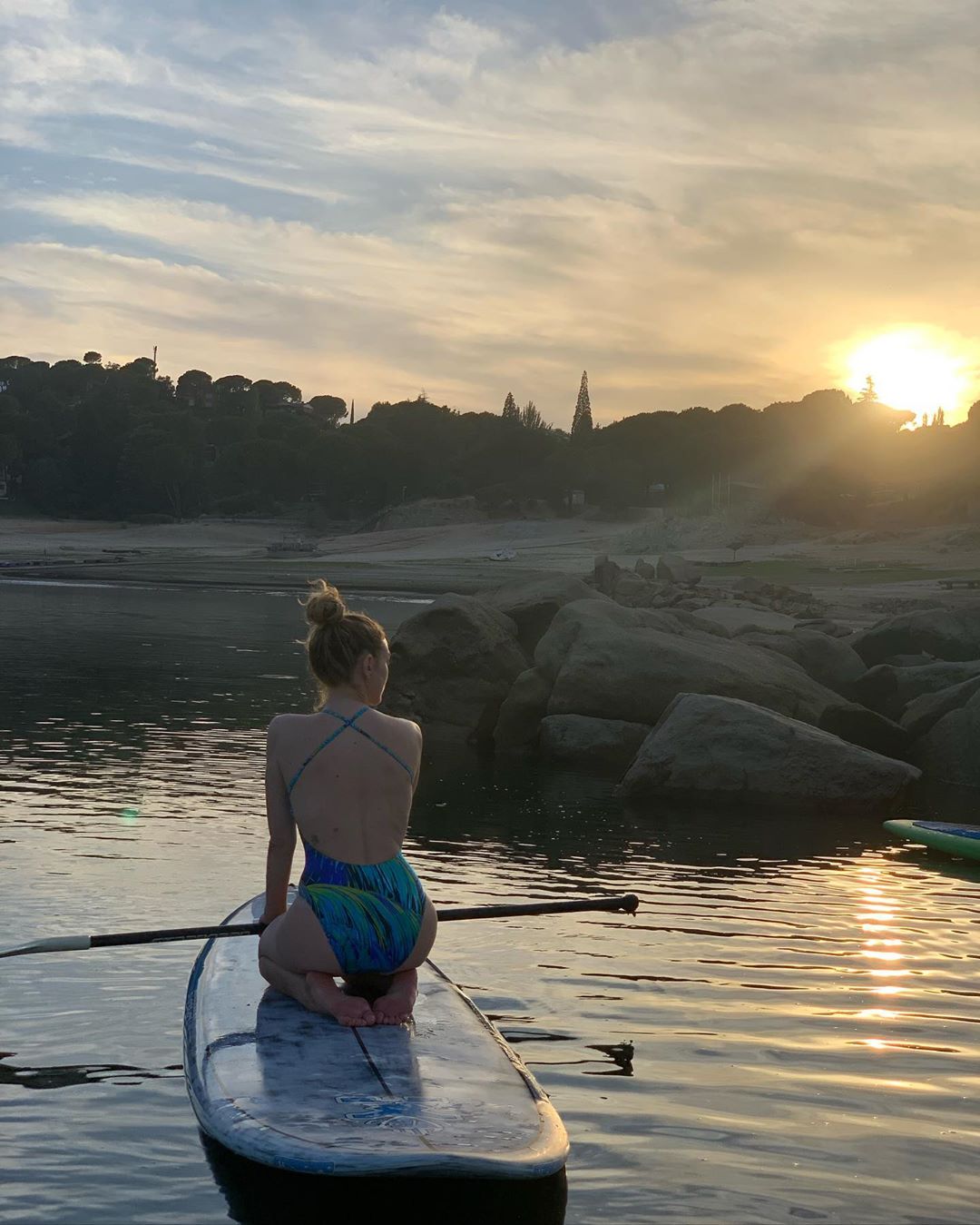 Momento paddle-surf con un bañador de espalda cruzada.