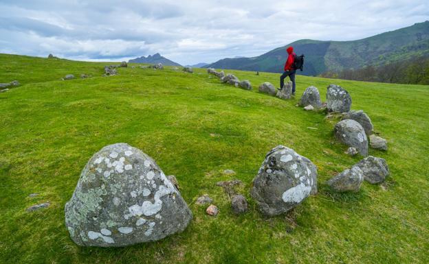 Un montañero examina el cromlech de Oianleku, en las Peñas de Aia.