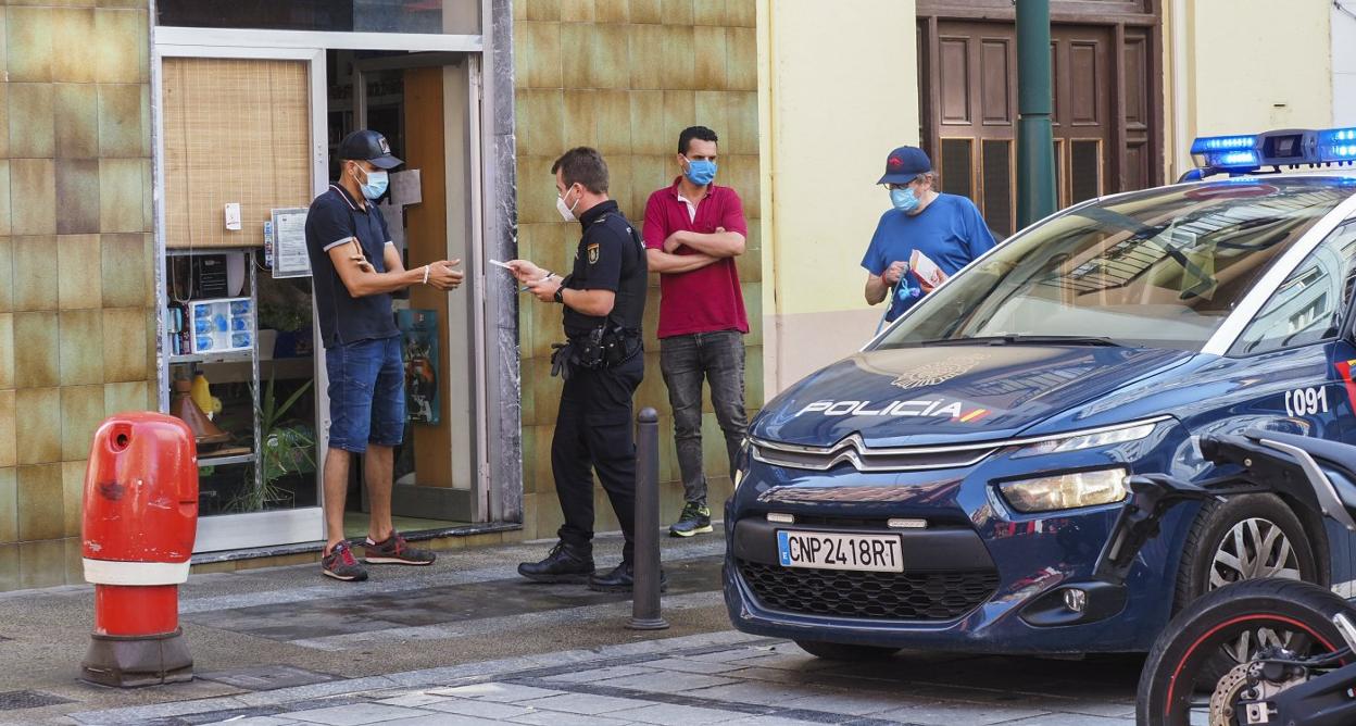 Un agente de la Policía Nacional entrega la documentación a un vecino en la calle Juan XXIII del barrio de La Inmobiliaria. 