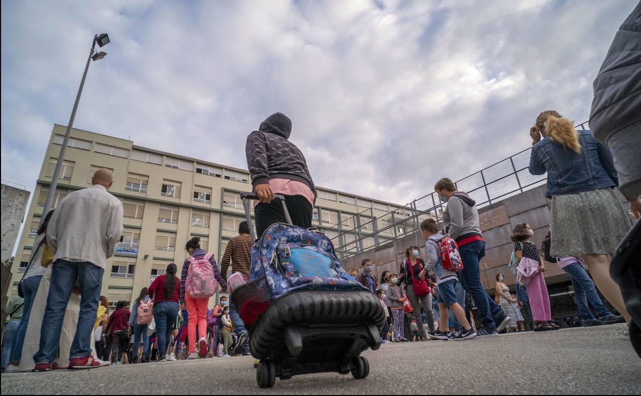 Padres y alumnos, ante la entrada de uno de los colegios de la capital.